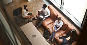 Top view of a group of 4 people sitting in a room during a meeting